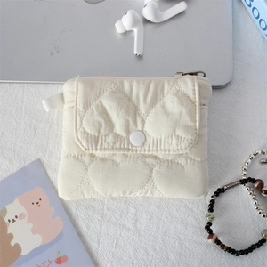 Close-up of quilted heart pattern organizer pouch with snap button and white carry strap