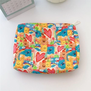 Close-up of quilted cotton makeup bag featuring colorful cartoon prints and zipper detail