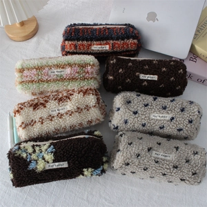 Close-up of various plush printed stationery pouches with soft fabric and May Rabbit label