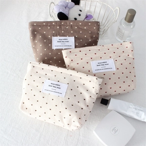 Polka dot heart canvas cosmetic bags in coffee, beige, and pink with a top zipper closure