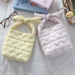 Detailed view of heart quilted fabric bags with bow handles and button closure