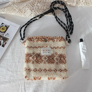 Detail of plush crossbody bag featuring sheepskin texture and mayrabbit brand tag