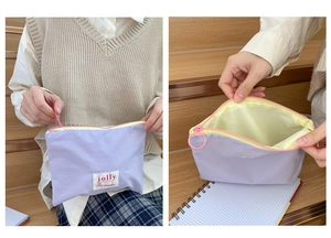 Detail of lavender nylon pouch with yellow waterproof lining and round pink zipper pull