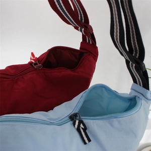 Nylon dumpling crossbody bags in red and light blue with adjustable striped webbing straps