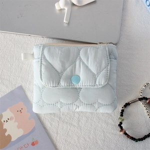 Detailed heart-quilted texture on a light blue mini pouch with a snap button flap