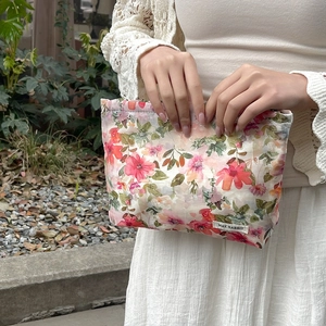 Detailed shot of fabric makeup bag with floral print and May Rabbit brand label