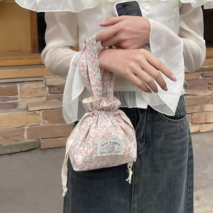 Detailed close-up of a floral drawstring handbag with a May Rabbit cloth label and soft handle
