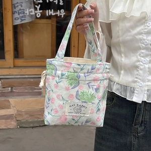 Detail of floral drawstring tote with May Rabbit logo and vintage blossom pattern