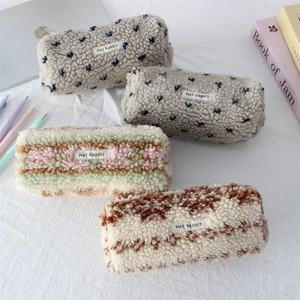 Fuzzy plush pencil cases in four prints with MAY RABBIT labels on a soft fabric background