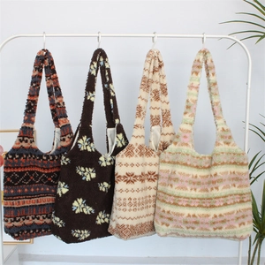 Detail of plush tote bags in various ethnic patterns hanging on a white rack