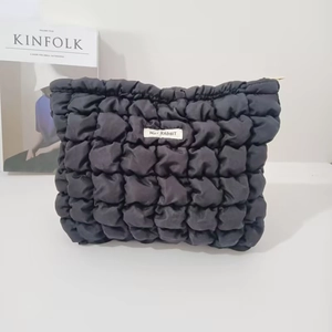 Detailed close-up of black quilted nylon bag featuring a Mat Rabbit brand woven label