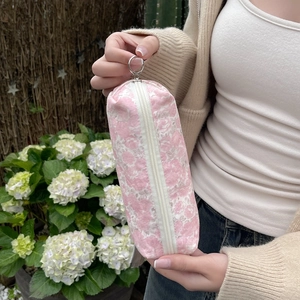Detail of floral makeup bag featuring pink flower patterns and metal ring zipper pull