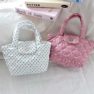 Detail showing mini quilted tote bags with polka dots and heart patterns in pink and white