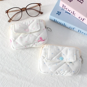 Detailed view of pink and blue quilted polka dot pouches with snap buttons and zippers