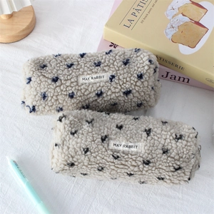 Detail of soft plush pencil cases with blue heart embroidery and metal zipper closure