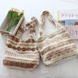 Detailed view of plush tote bags featuring ethnic snowflake and colorful stripe patterns