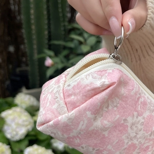 Detailed macro view of the floral cosmetic bag featuring a large silver metal ring zipper