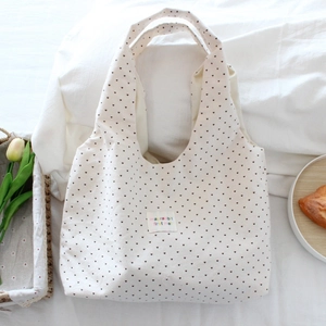 Detail of canvas tote bag with heart patterns and colorful letter embroidery