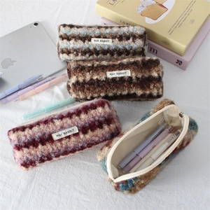 Detail view of plush textured pencil cases with various patterns and woven rabbit label