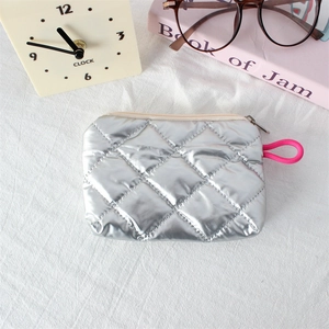 Macro shot of silver quilted faux leather coin purse with zipper and bright pink loop