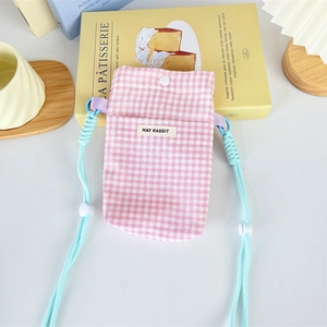 Detailed shot of pink checkered crossbody phone bag with snap button and blue strap