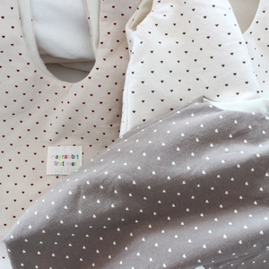 Detail of soft cotton baby sleep sack with heart patterns and brand logo tag labels