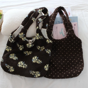 Detail of plush brown teddy fabric tote bags with floral patterns and snap closure button