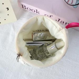 Macro shot of white quilted pouch interior with zipper detail and cosmetic storage