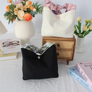 Detailed view of bubble texture fabric handbags with floral bow accents and button closure