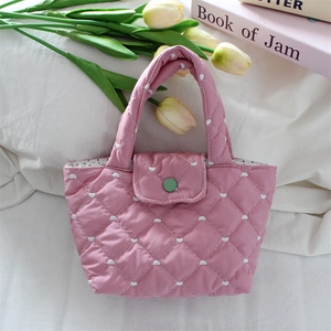 Detail of pink quilted heart bag with green snap button and polka dot lining
