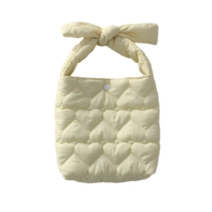 Pale yellow quilted heart handbag with bow handle and snap closure for women