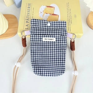 Detail of navy checkered crossbody phone bag with snap button and cord strap