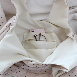 Interior view of tote bag with inner zipper pocket holding a phone and glasses
