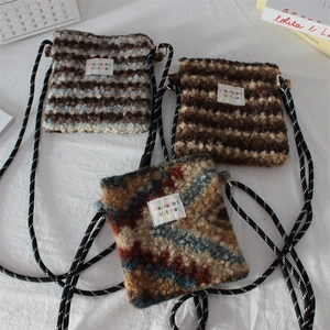 Flat lay of three plush faux fur mini crossbody bags with diverse prints and letter patches