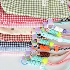 Detail of candy-colored plaid and polka dot phone pouches with woven lanyards