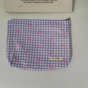 Detailed close-up of a floral toiletry bag featuring pink bows and a fabric label