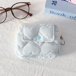 Detail of light blue heart-quilted coin purse with snap flap and round zipper pull
