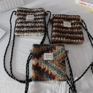 Detailed view of three plush crossbody bags with striped knit texture and rope straps