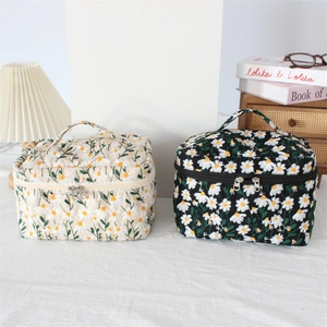 Quilted daisy embroidery cosmetic bags in beige and black with dual zippers and handles