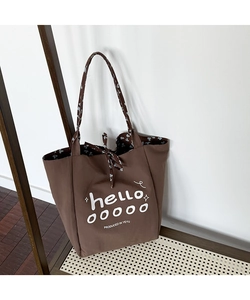 Detail of dark brown tote bag with floral lining and artistic letter printing
