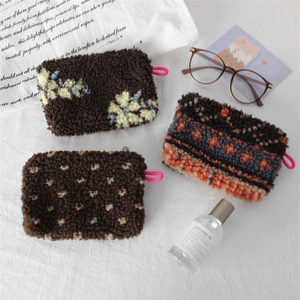 Vintage plush cosmetic bags in floral and geometric patterns with pink zipper loops