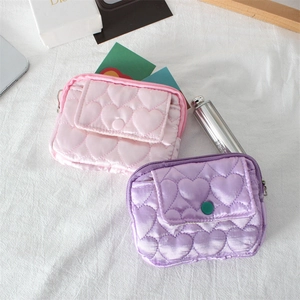 Dettaglio di portamonete in raso trapuntato a cuore rosa e viola con chiusura a scatto