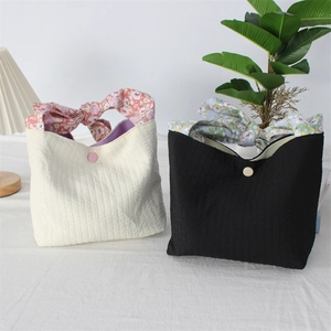 Detail of seersucker tote bags with floral bow handles and button closure