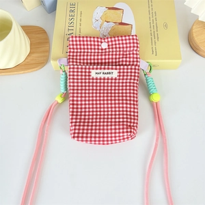 Detail of red checkered crossbody phone bag with snap closure and May Rabbit embroidery
