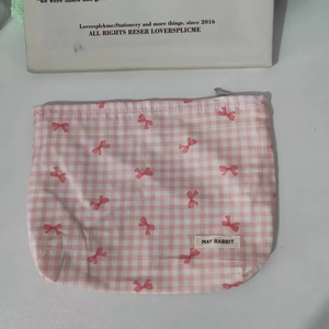 Close-up of floral makeup bag with pink bow pattern and MAY RABBIT label detail