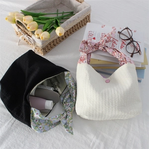 Chic striped tote bags in black and cream featuring floral ribbon bow handles and textured fabric