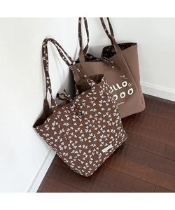 Detailed view of brown floral canvas tote bag with tie closure and printed patterns