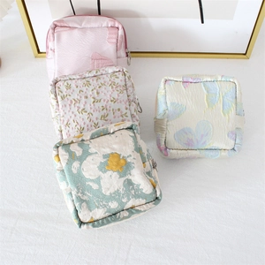 Macro view of floral jacquard pouches with metal zippers in various colorful patterns