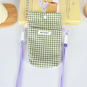 Detail of green plaid phone bag with purple rope strap and white snap closure