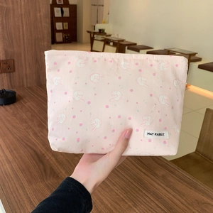 Close-up of pink makeup bag with cute rabbit and strawberry patterns and zipper detail